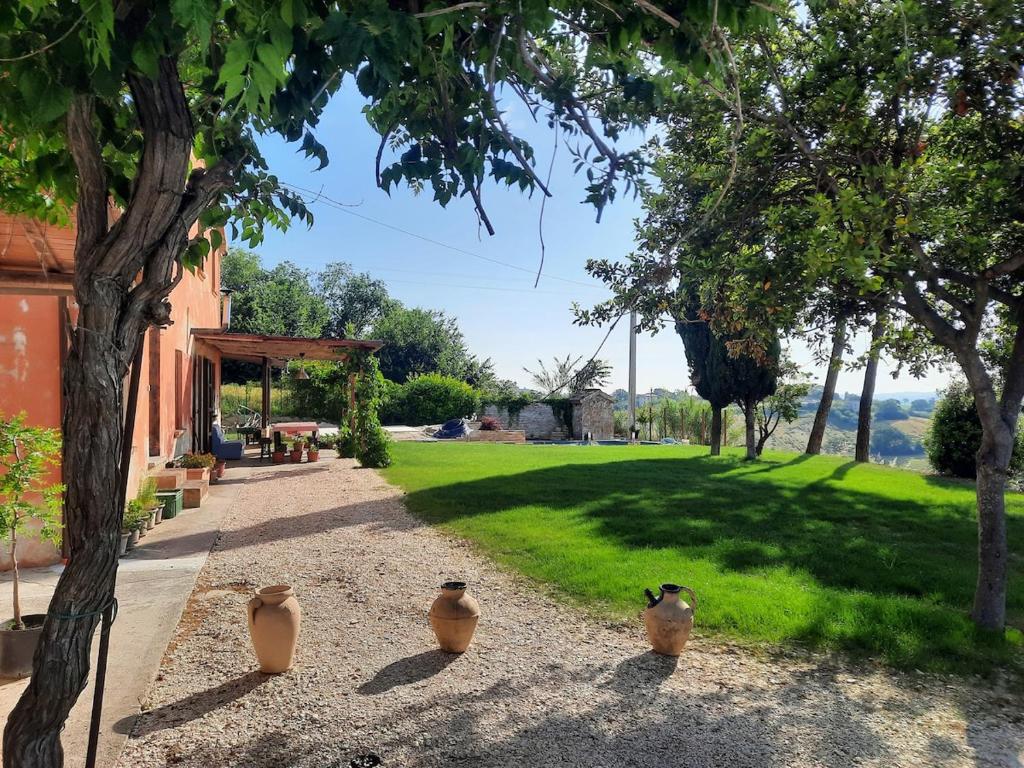 a group of three vases sitting on the ground next to a yard at Alloggi degli Artisti in Case Selva Grande