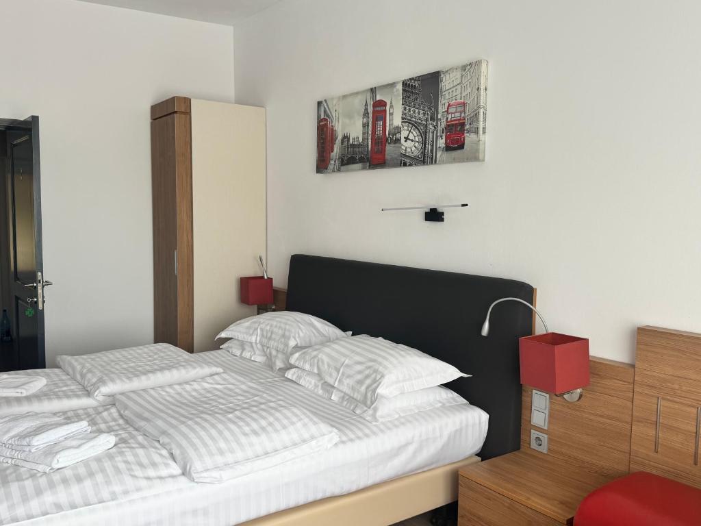 a bedroom with a bed and a red chair at La Romică in Mediaş