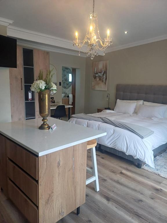 a bedroom with two beds and a table with a counter at Maison De Blom in Aliwal North