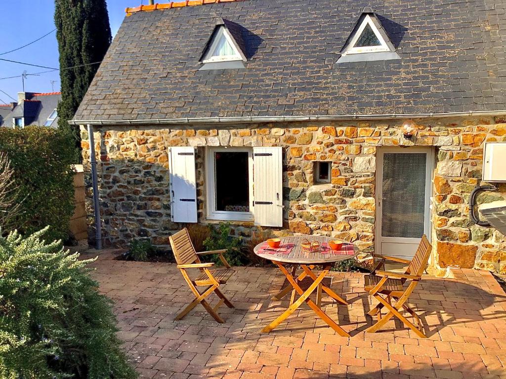 a table and chairs in front of a stone cottage at Penty in Crozon