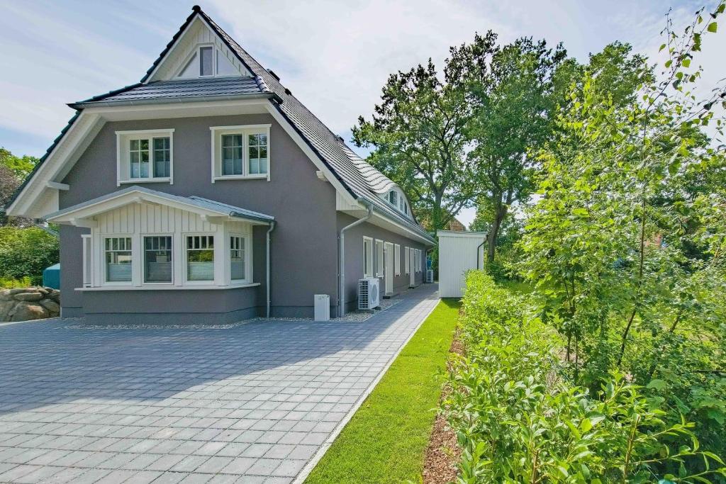 a gray house with a gambrel roof and a driveway at Darss Duett 2 in Prerow