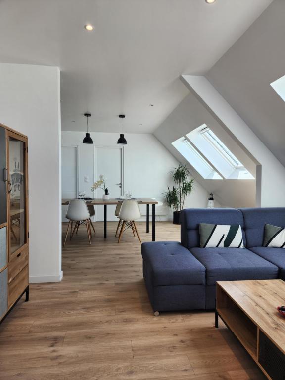 a living room with a blue couch and a table at O'Phare Ouest in Plouguerneau