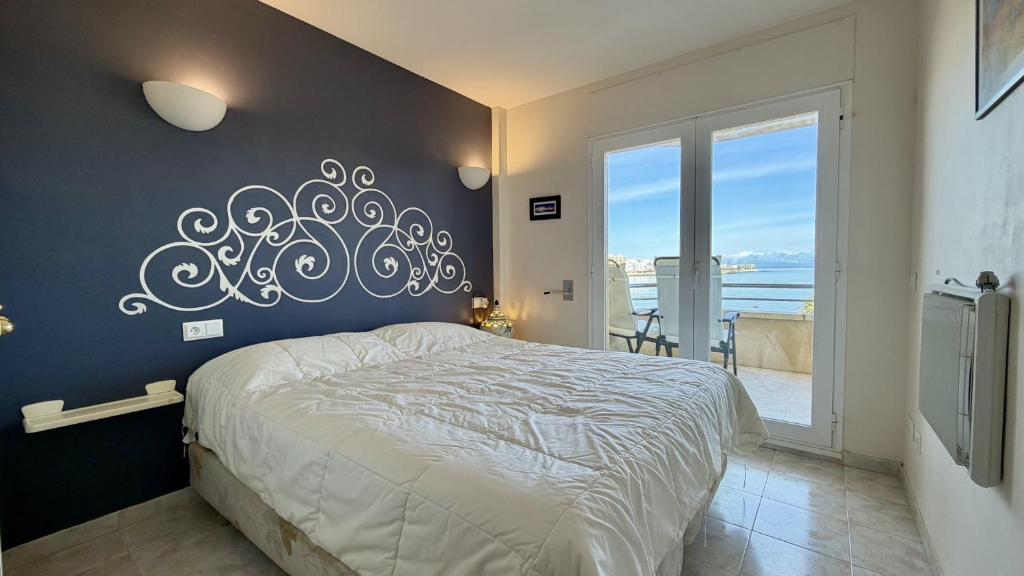 a bedroom with a large bed and a large window at La Llongada 2-C in L'Escala