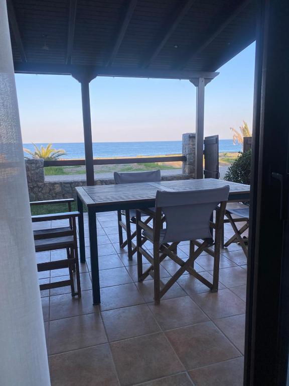 a table and chairs on a patio with a view of the ocean at Villa Agali in Agia Anna