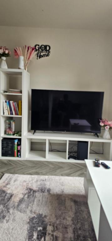 a living room with a large flat screen tv at Private room in a 2-bedroom house in Dinnington