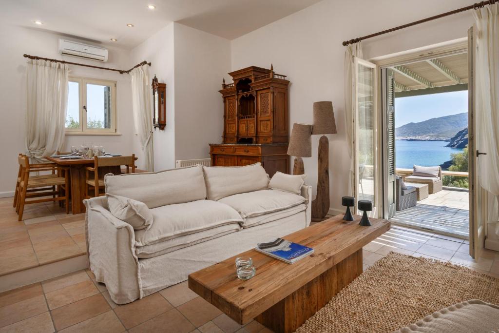 a living room with a couch and a table at Horizon Beach House by Andros Villas Collection in Andros