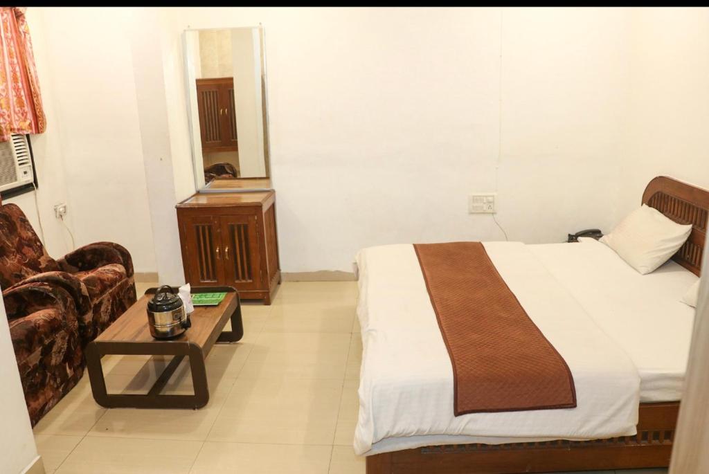 a hotel room with a bed and a coffee table at Hotel Meghdoot in Pachmarhī