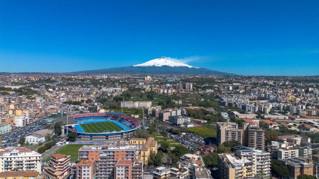 a view of a city with a snow covered mountain at Mi casa tu casa - Guest House in Catania