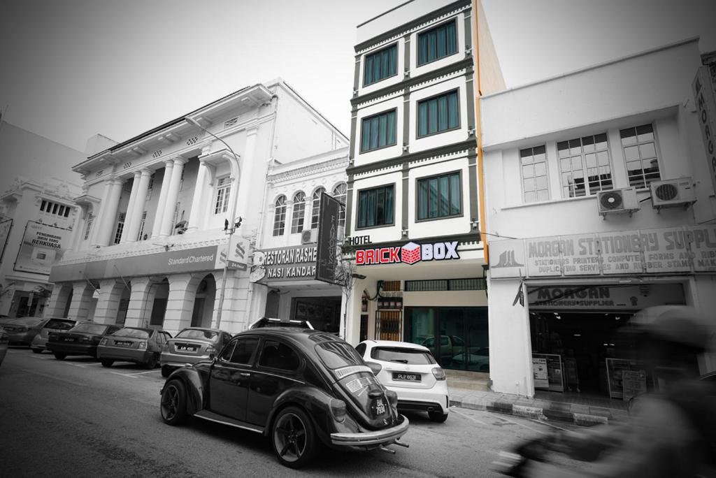 a small car parked on the side of a city street at Brick Box Hotel @ Oldtown Ipoh in Ipoh