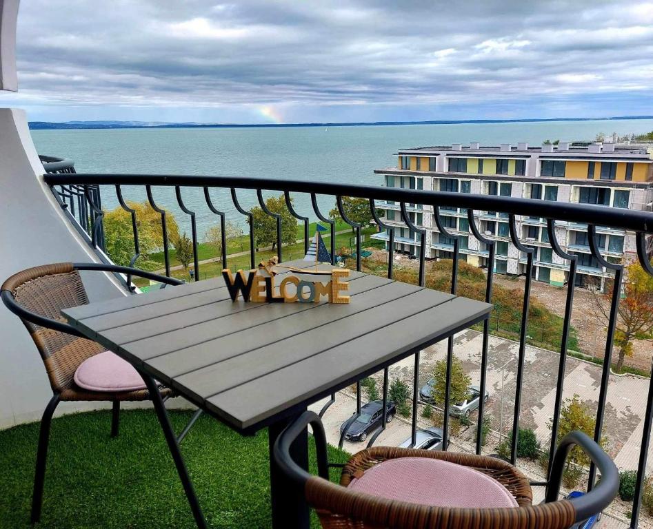 a table on a balcony with a view of the ocean at Türkiz Apartman in Siófok