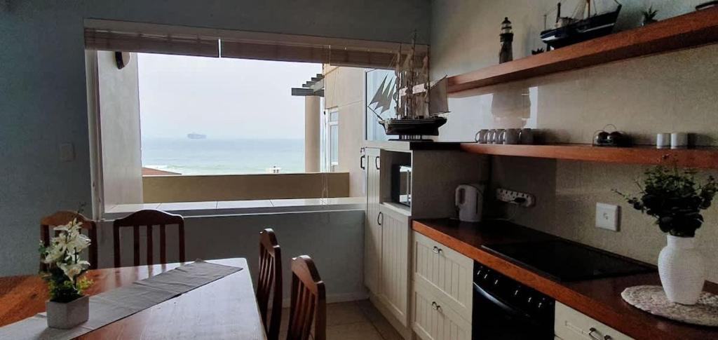 a kitchen with a table and a view of the ocean at CUTTY SARK in Langstrand