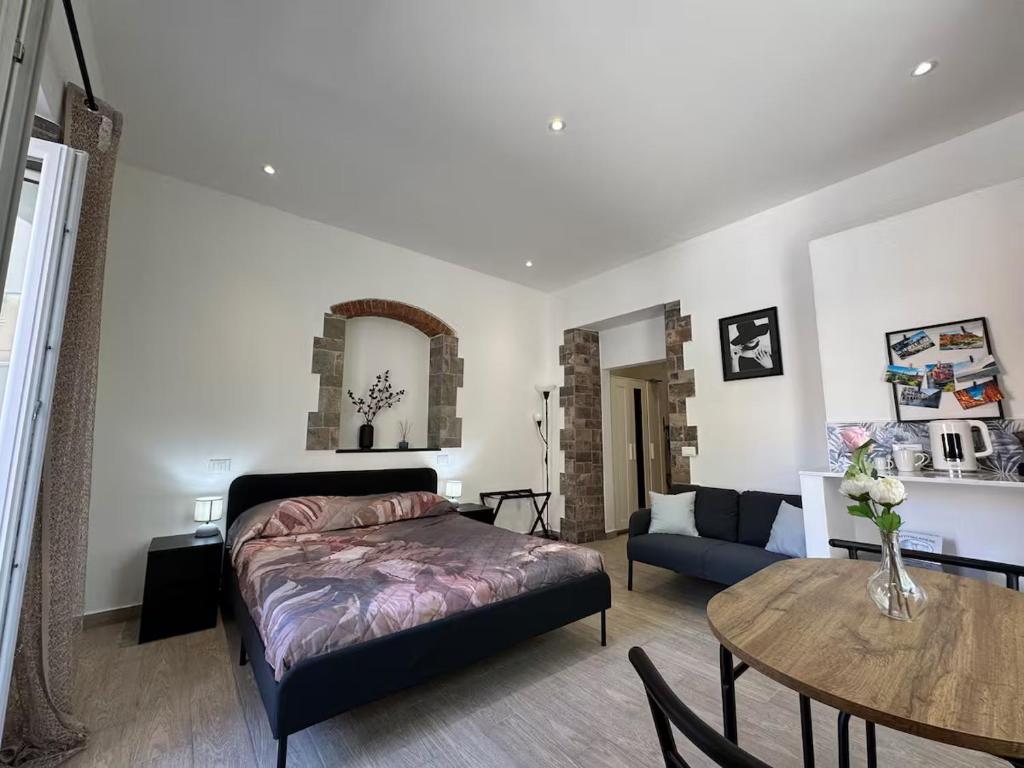 a bedroom with a bed and a table and a couch at SOBBORGO 34 - Affittacamere - in Sarzana