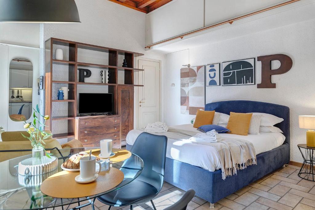 a bedroom with a blue bed and a table and chairs at Studio Apartment 1 Min From Lake in Como