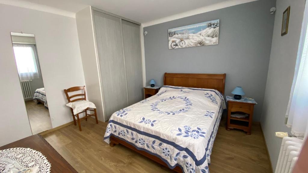 a small bedroom with a bed and a chair at Paisible in La Celle-sous-Gouzon