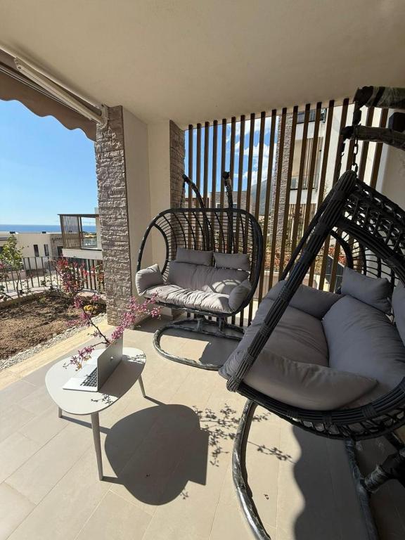a patio with two chairs and a couch on a balcony at Everbright Seaside Serenity in Himare