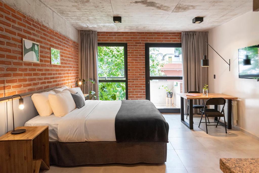 a bedroom with a bed and a brick wall at H5063 in Buenos Aires