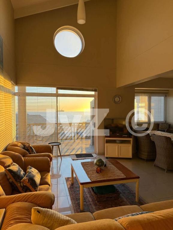 a living room with couches and a table at Dolphin View 32 in Langstrand