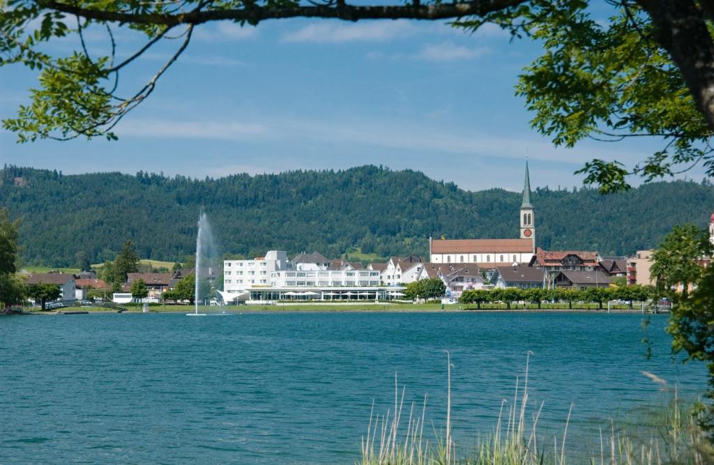 a large body of water with a town and a church at SeminarHotel am Ägerisee in Unterägeri