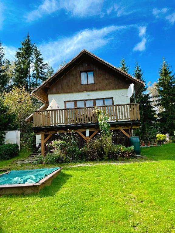a large house with a deck and a swimming pool at Chata Monika in Frymburk