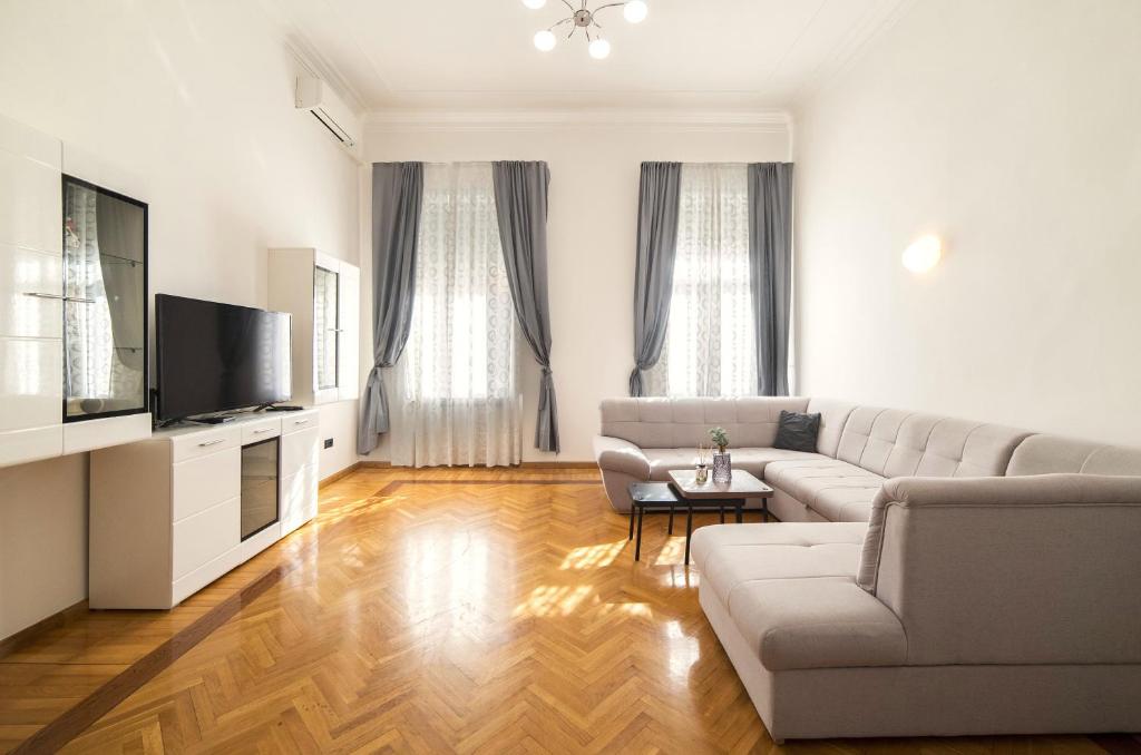 a living room with a couch and a tv at Golden Star Apartment - Spacious City Center Stay in Zagreb