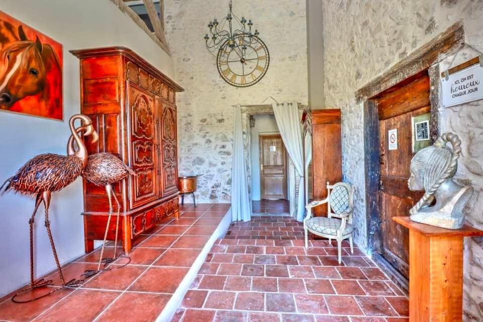 a living room with a large tiled floor at Le Triol in Les Fournials