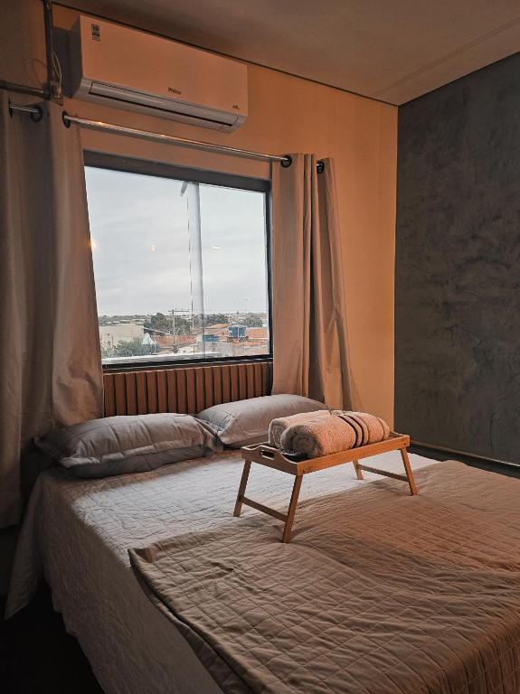 a room with two beds and a large window at D Castro Residencial in Montes Claros