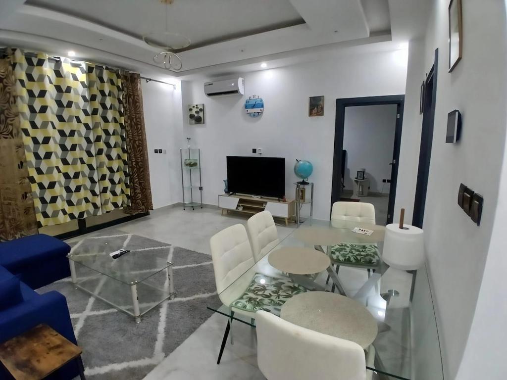 a living room with a glass table and white chairs at le laurier 9 in Abidjan