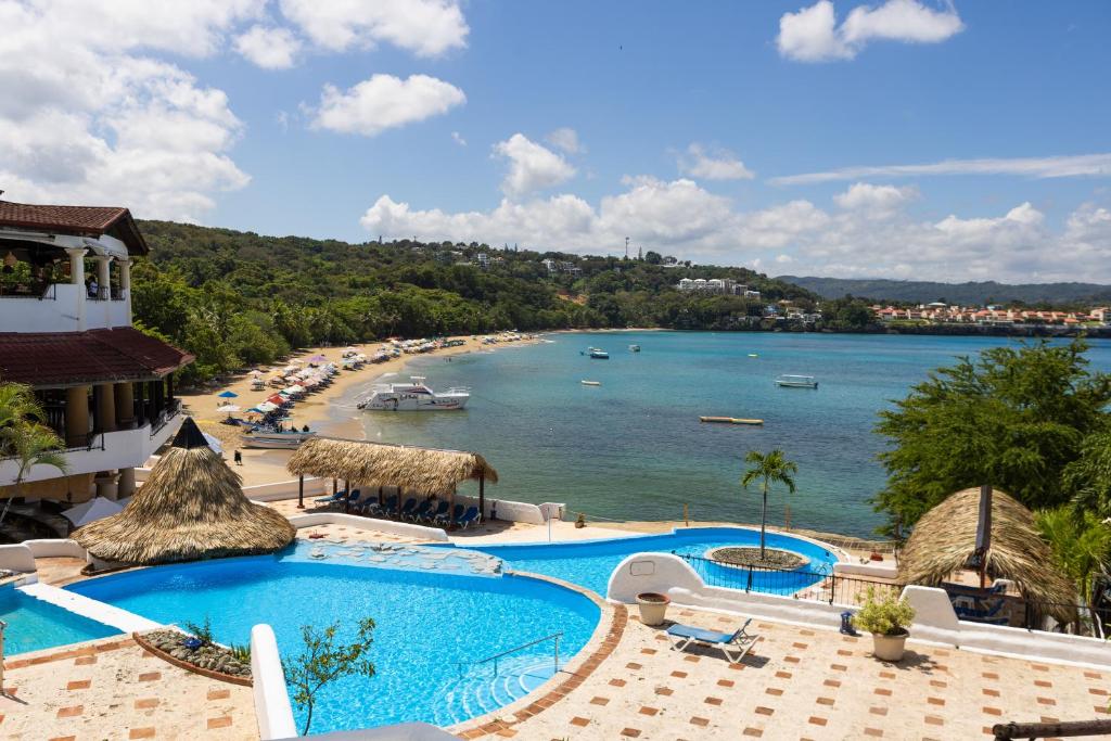 a view of a beach from a resort with two pools at Hotel Croma Sosua Beach in Sosúa