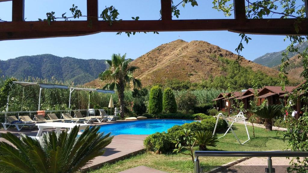 Ein Resort mit Pool und Bergen im Hintergrund in der Unterkunft Ada Adrasan Hotel in Kumluca