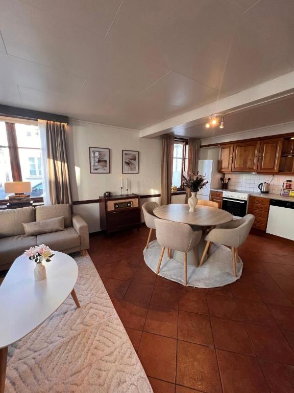 a living room with a table and chairs and a kitchen at The Old Bakery in Grimstad