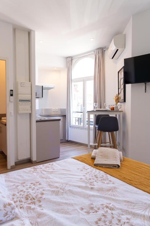 a kitchen with a table and a stool in a room at Les suites du pont Joffre in Perpignan
