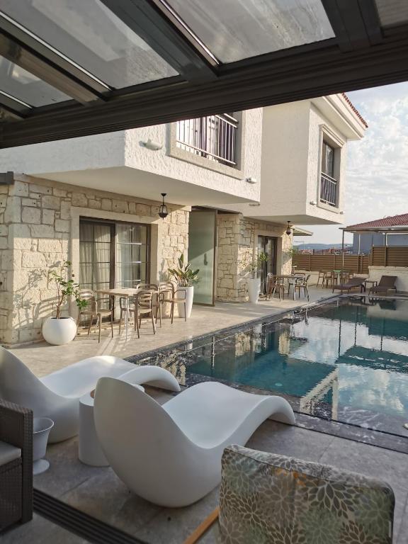 a house with a swimming pool and a patio at Olea Alacati in Çeşme