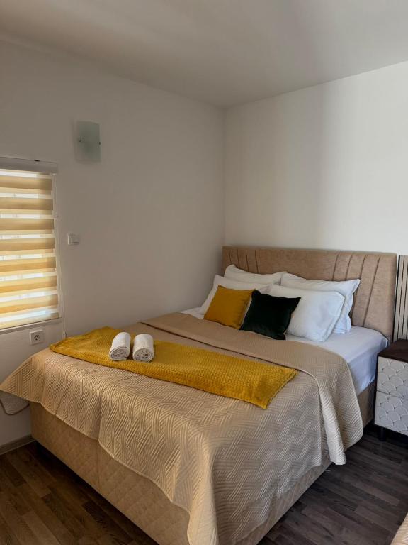 a bedroom with a bed with two slippers on it at Apartmani Vučinić in Cetinje