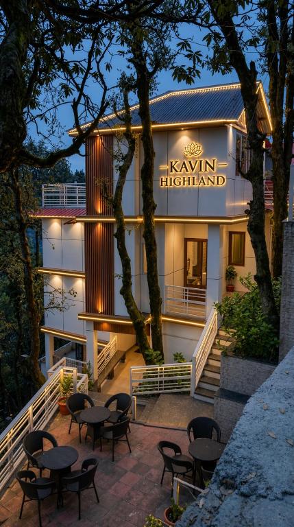 a hotel with tables and chairs in front of it at Kavin Highland - The Mall Dalhousie in Dalhousie