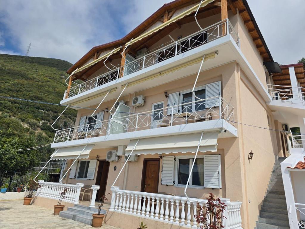 a house with a balcony and a hill in the background at Arthur's 4Apartments in Borsh