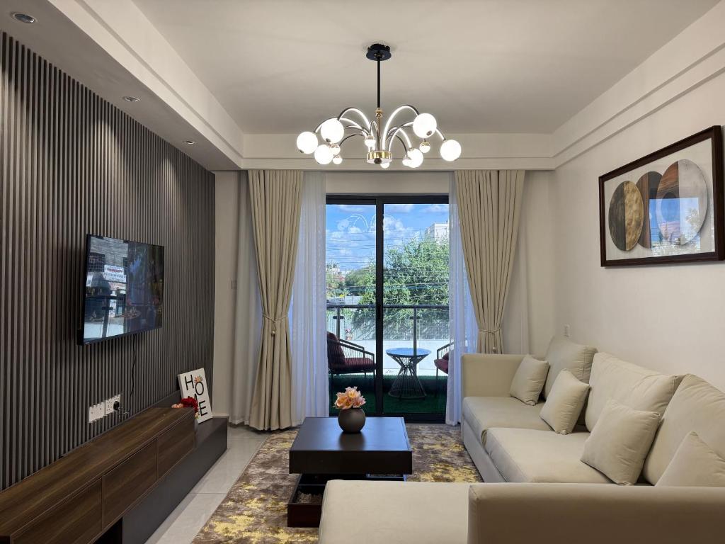 a living room with a couch and a chandelier at Nessie Homes in Nairobi