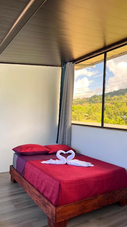 a bed in a room with a large window at Matapalo Hosting in Savegre