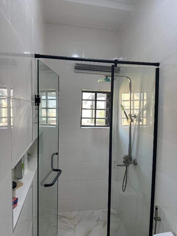 a bathroom with a shower with a glass door at Floesth Ville in Mama