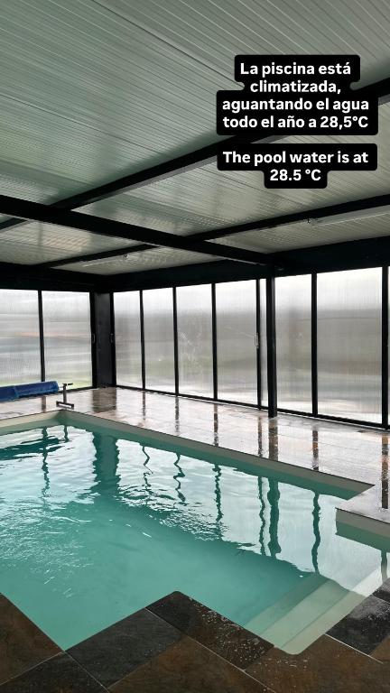 a swimming pool in a building with a sign above it at Casa Pepe in Ourense