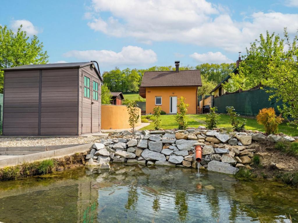 a man standing in a pond in front of a house at Chalet U Pstruha in Vimperk