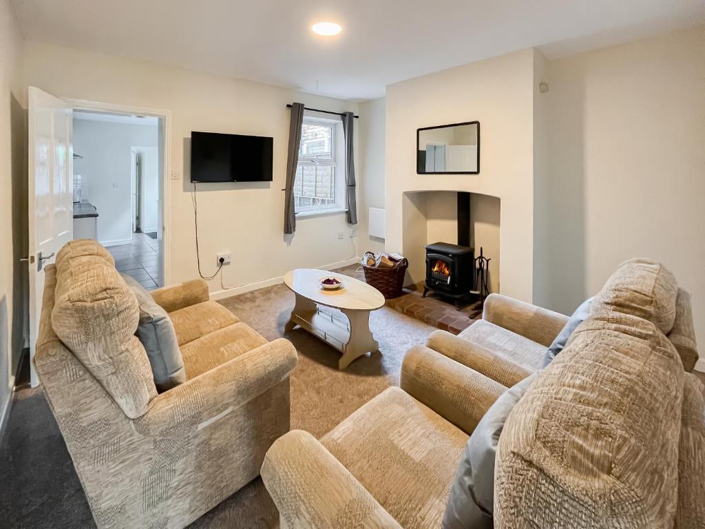 a living room with two couches and a fireplace at Billada Cottage in Firsby