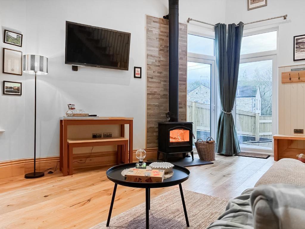 a living room with a table and a fireplace at The Coal House in Skipton