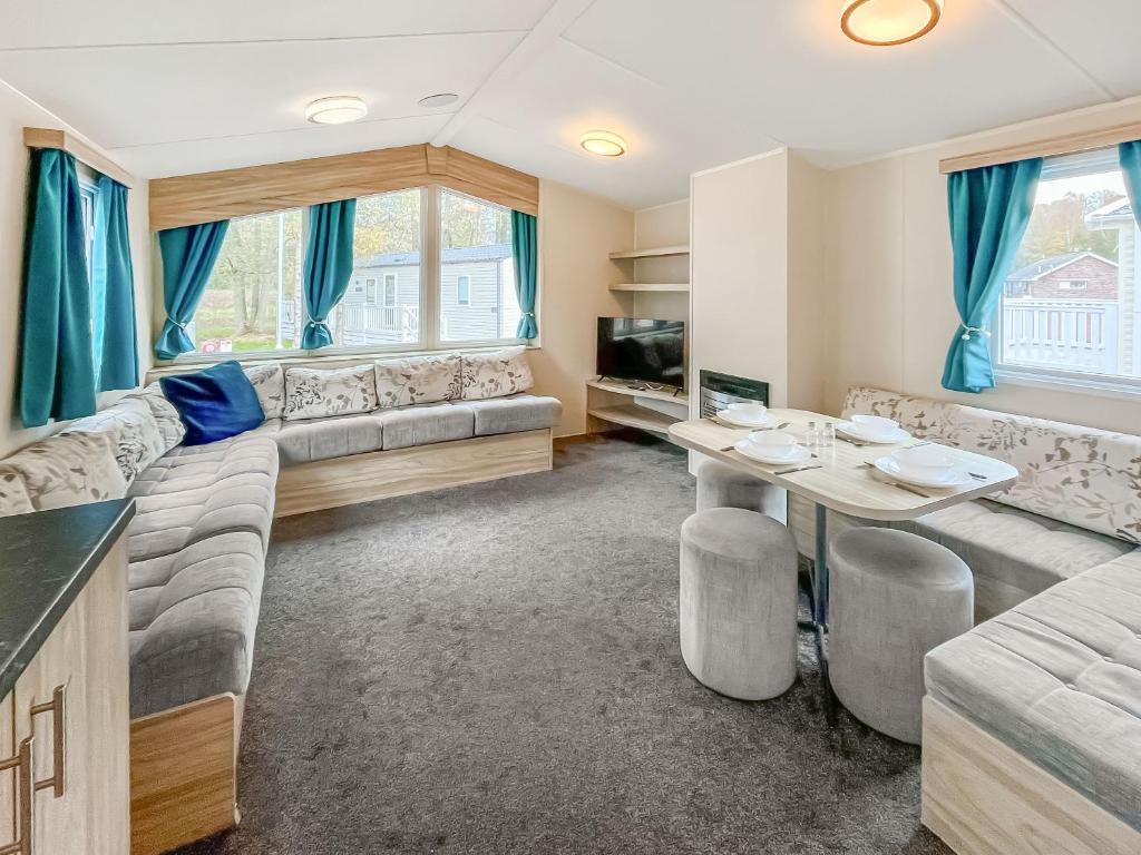 a living room with a couch and a table at Eskside Lodge in Brechin