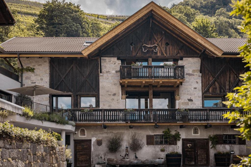 ein Haus mit einem Balkon auf dem Dach in der Unterkunft Bäcksteinerhof in Meran