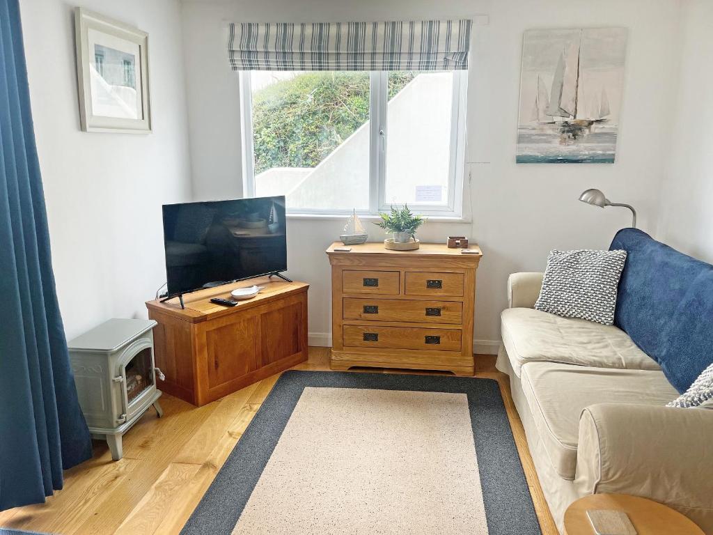 a living room with a couch and a tv at The Sail Room in Saint Mawes