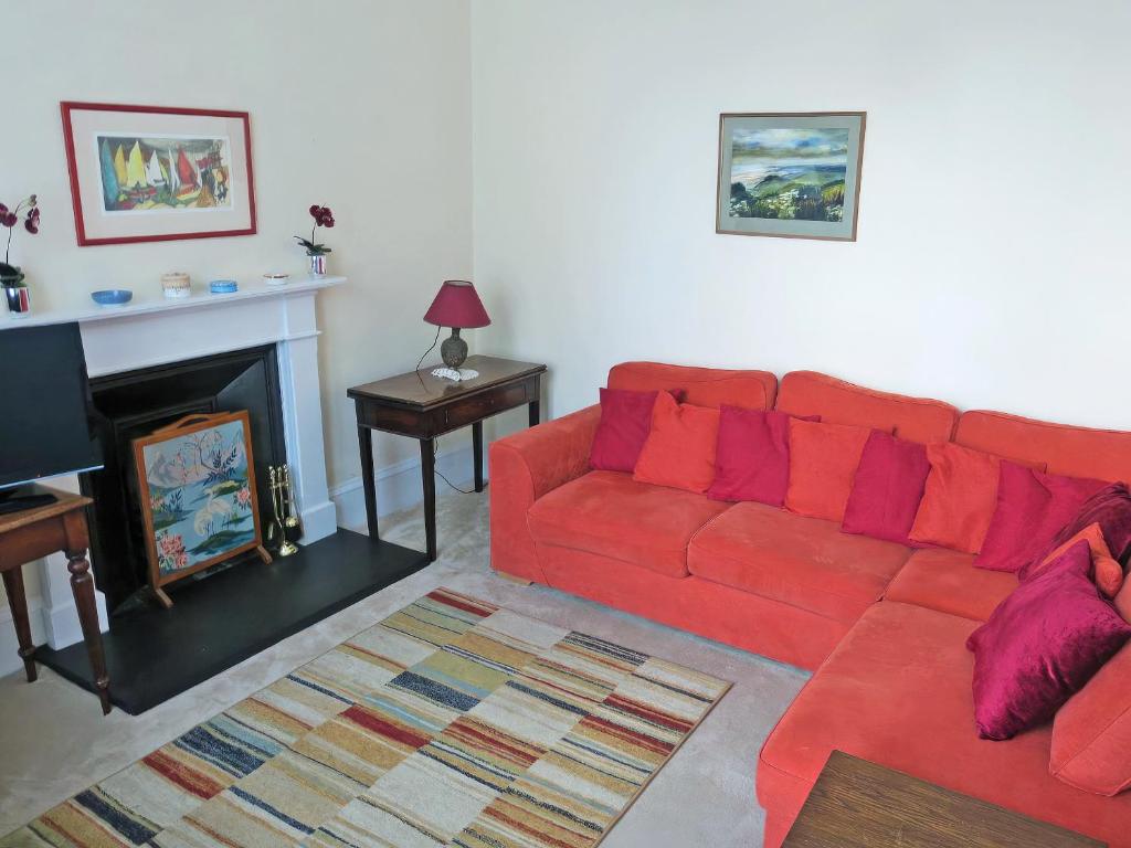a living room with a red couch and a fireplace at The Townhouse in Inverness