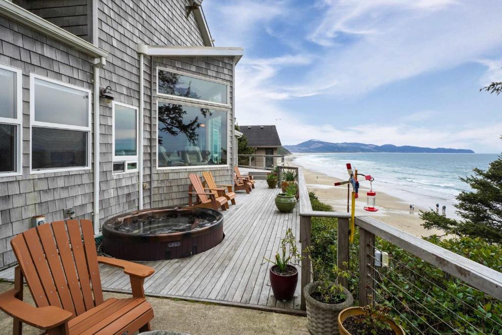 a deck with a hot tub on the side of a house at Ocean's Edge in Tillamook