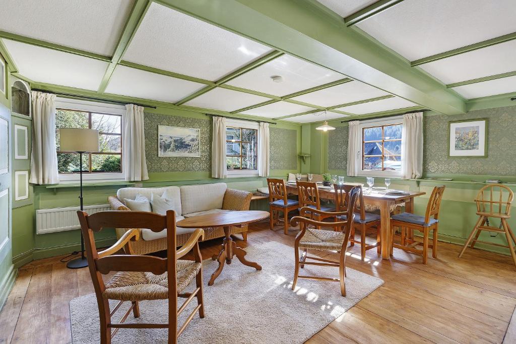 a living room with green walls and a table and chairs at Bachrainhof 2 in Menzenschwand