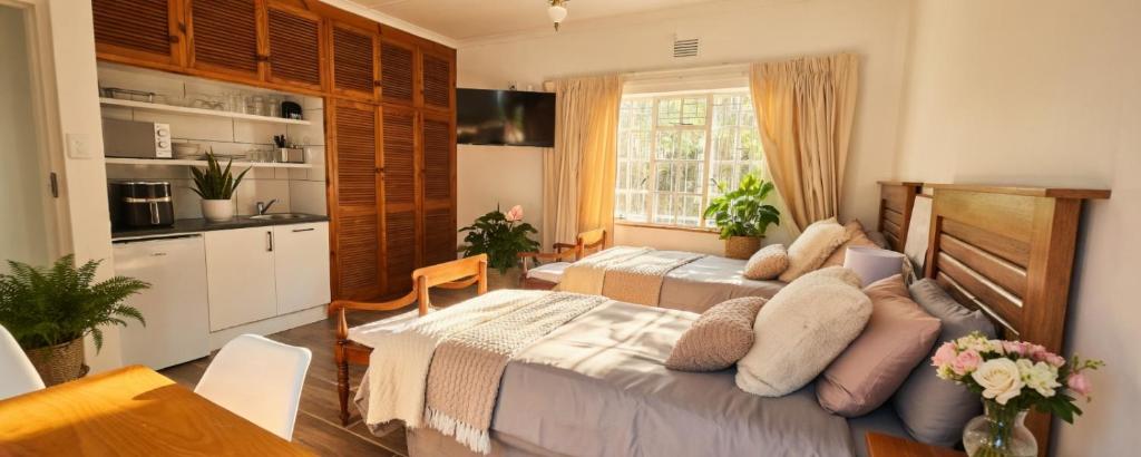 a bedroom with two beds and a kitchen at Rus en Vrede BackPackers Cottage! in Knysna