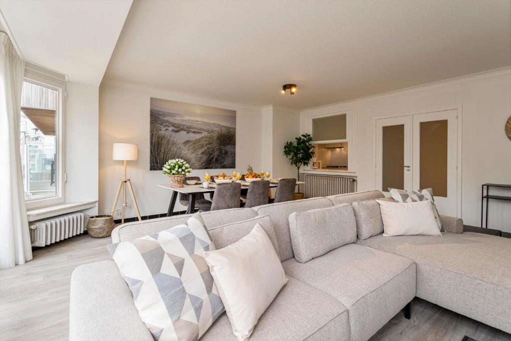 a living room with a couch and a table at Flat Julien in De Panne